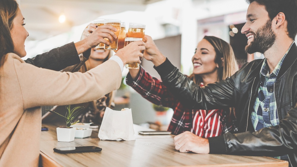 A group of friends cheers glasses at a craft brewery