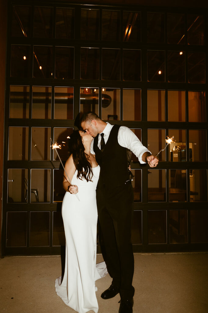 Bride and groom kissing with sparklers