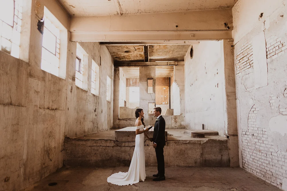 Bride and groom first look in a raw warehouse in Denver