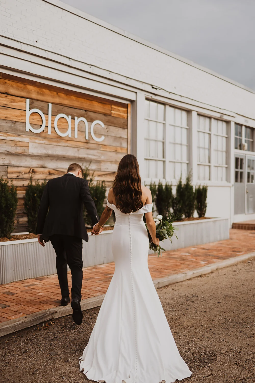 Bride and groom taking photos outside of Blanc in Denver