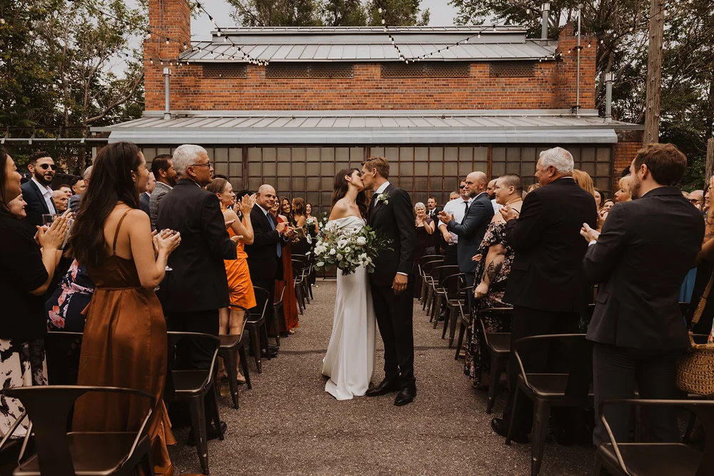 Bride and groom kissing after they say "I do" at Blanc
