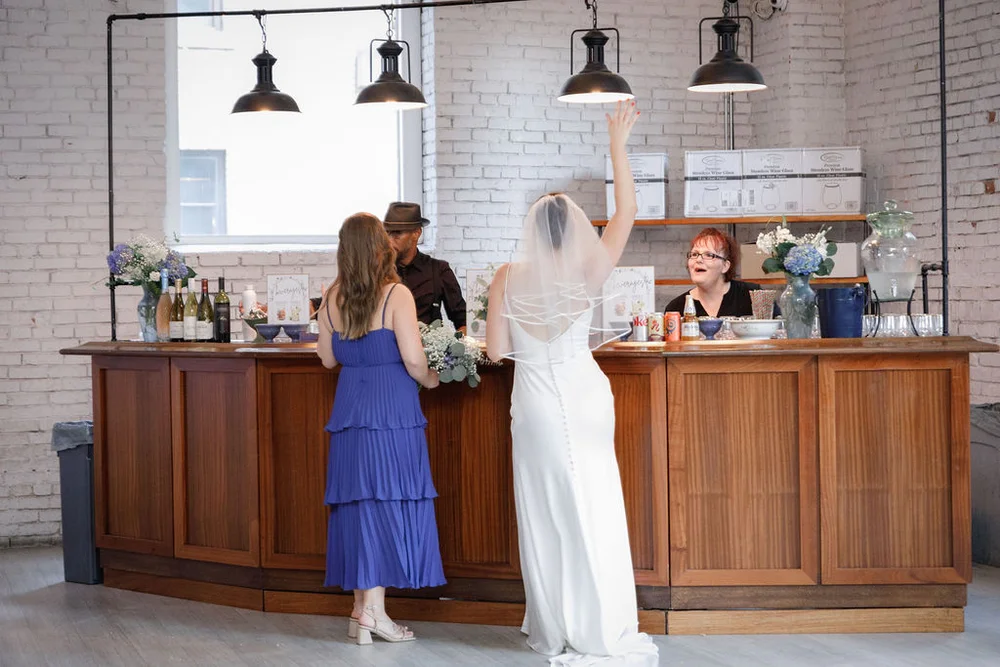 Bride and guest standing at the bar at THE 101 during a wedding