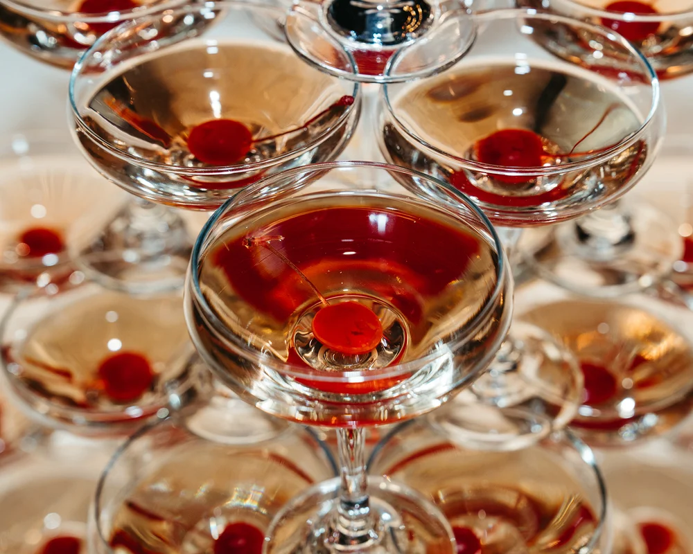 Champagne tower with glasses filled with cherries at a moody ’Til Death wedding open house at SKYLIGHT Denver by 828 Planning