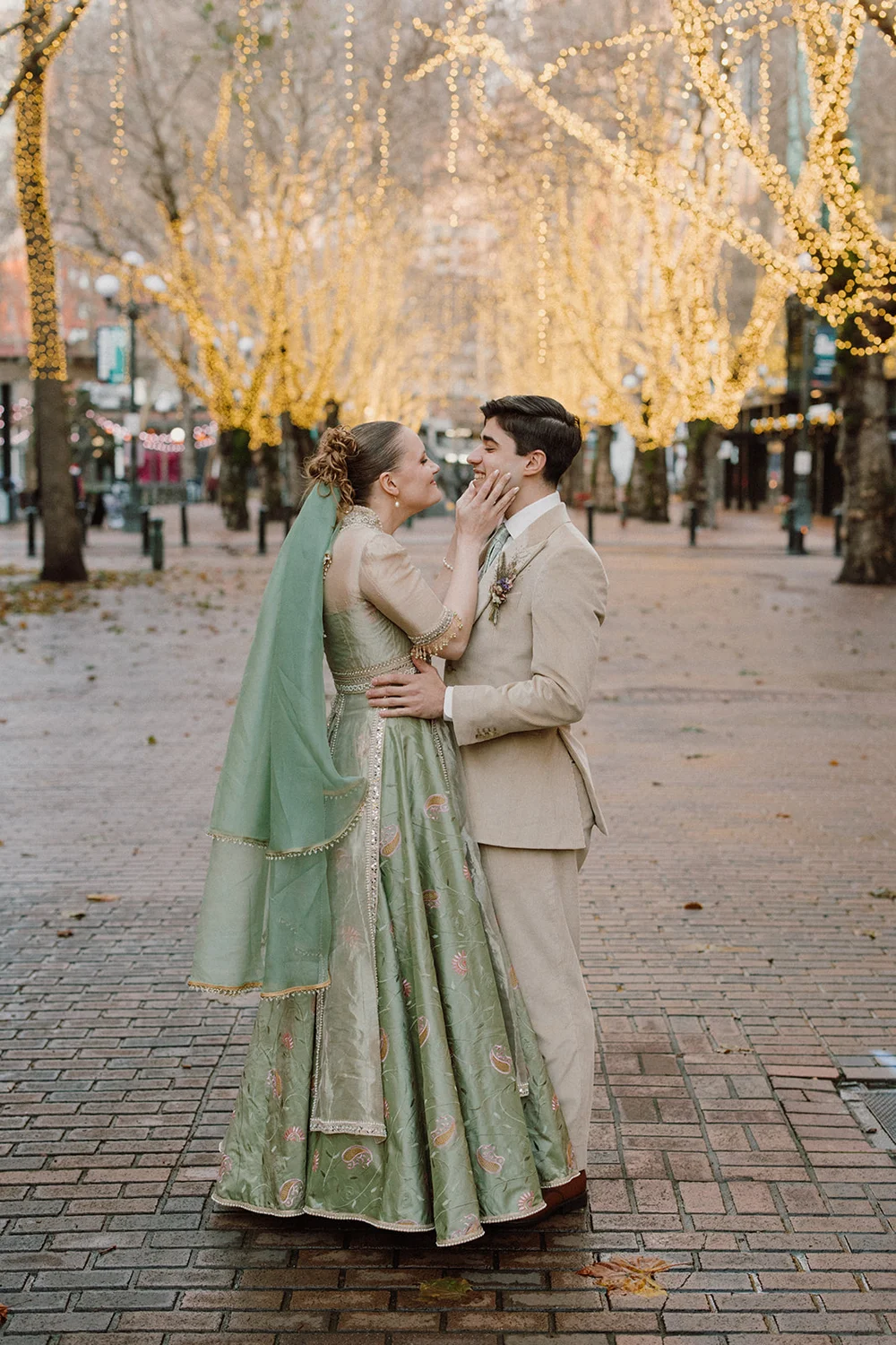 Bride and groom looking at each other outside with twinkling lights in the background