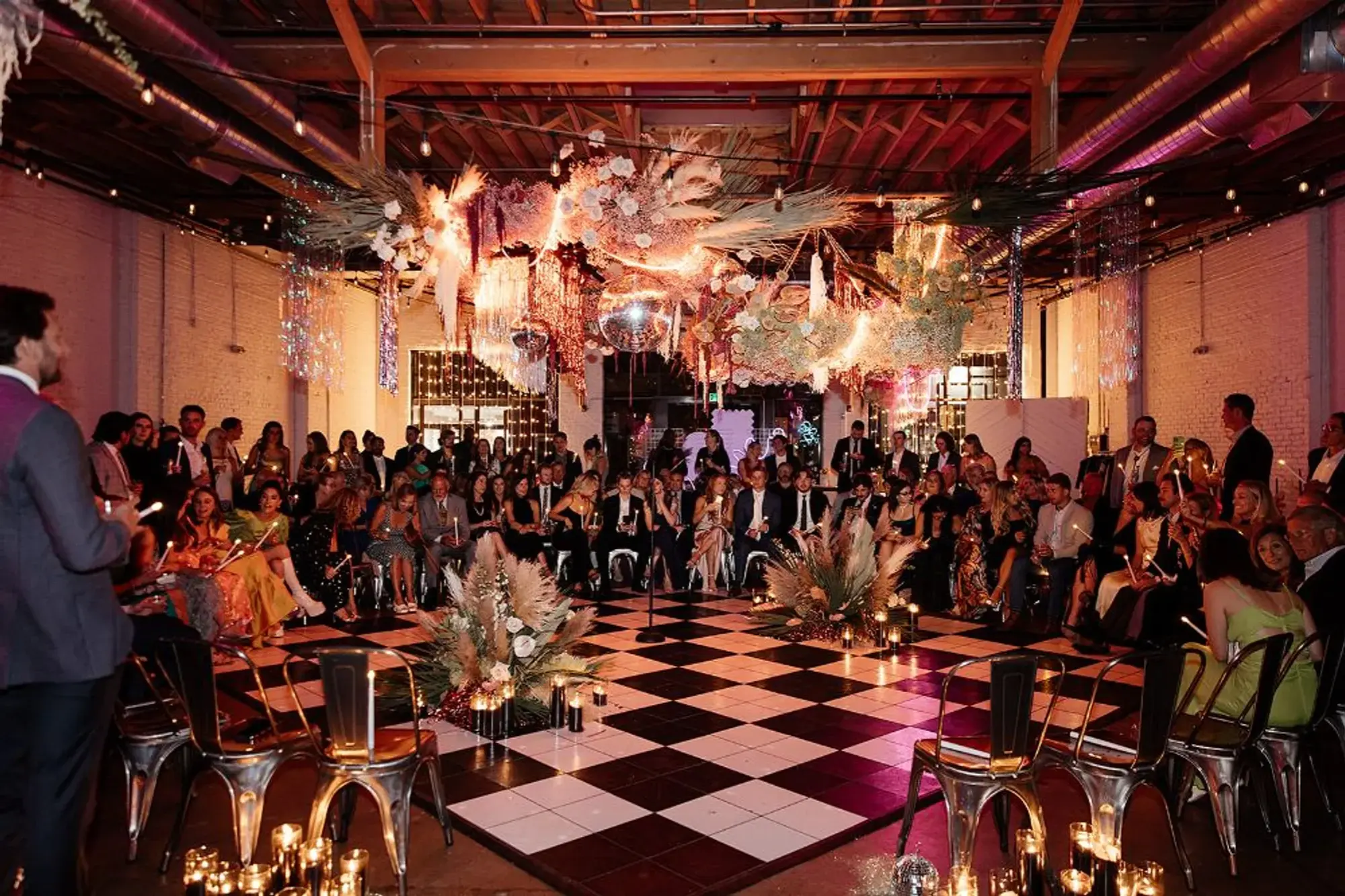 Disco jungle wedding ceremony setup with black and white dance floor and large boho installation overhead